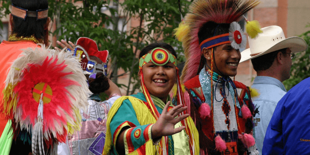 Group of smiling individuals in colorful traditional attire at a cultural event