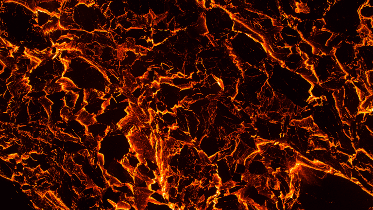 Abstract volcanic texture with glowing orange and black cracks resembling molten lava.