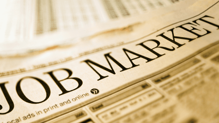 Close-up of a newspaper headline reading "JOB MARKET" with job listings below