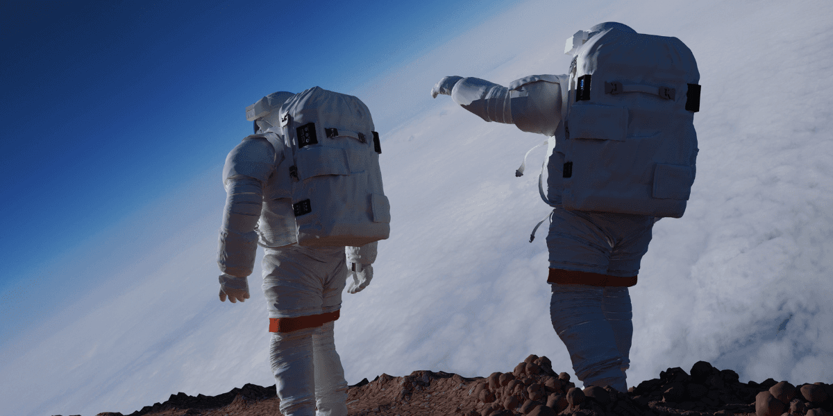 Two astronauts in space suits standing on a rocky surface above clouds
