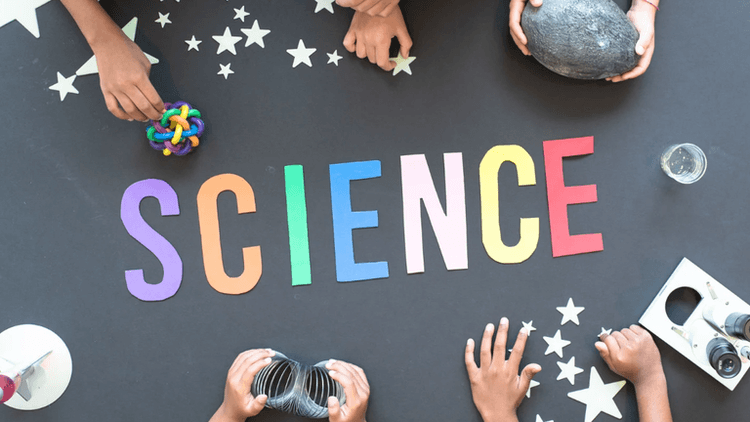 Colorful letters spell "SCIENCE" surrounded by hands and various science-related objects and materials