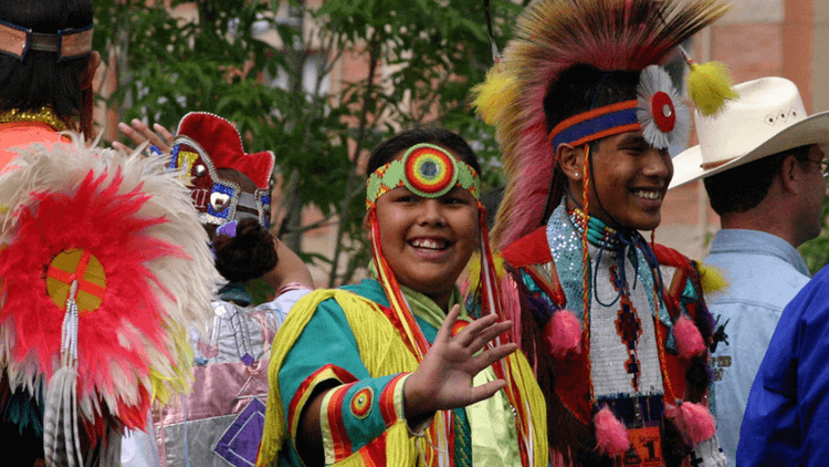 Group of smiling individuals in colorful traditional attire at a cultural event